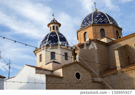 Blue tiled domes of Altea's historic church stand against a bright sky, inviting travelers to explore this charming Spanish city's cultural beauty and enjoy unforgettable holidays 138995927