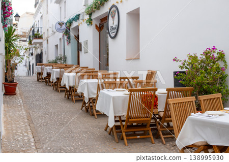 Restaurant terrace on a historic cobblestone street in Altea Spain awaits guests for a delightful al fresco dining experience during a memorable family holiday 138995930
