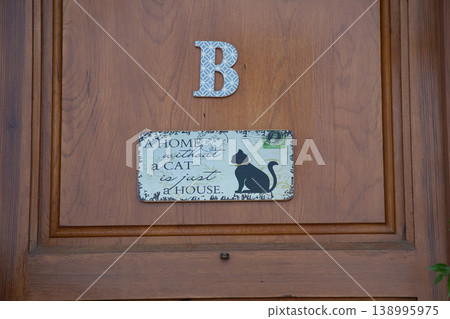 Cozy Altea city entrance features a delightful wooden door sign with a black cat silhouette and the saying A home without a cat is just a house, ideal for family vacation memories in Spain 138995975