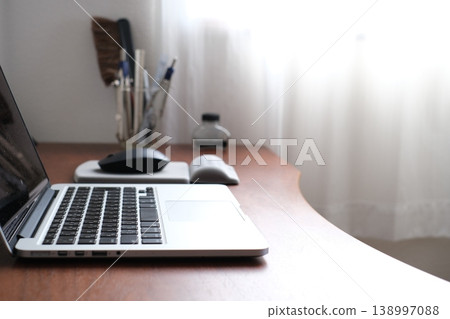 Hands of a man typing on a keyboard while working remotely 138997088