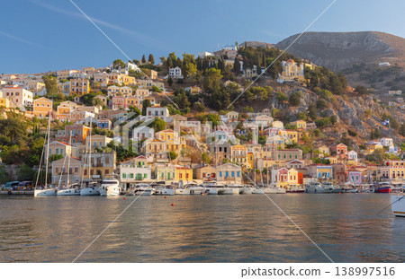 Sailboats in harbor with hillside houses in Symi, Greece Sailboats in harbor with hillside houses in Symi, Greece 138997516