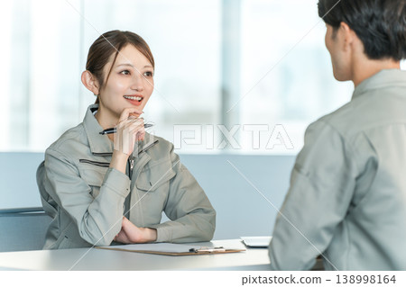 身著工作服的男女製造工人和工廠工人在會議室開會/討論。 138998164