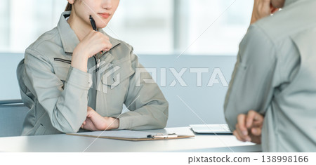 身著工作服的男女製造工人和工廠工人在會議室開會/討論。 身著工作服的男女製造工人和工廠工人在會議室開會/討論。 138998166