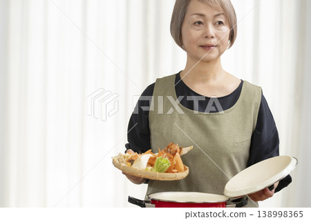 廚房裡,一位老婦人正在煮蔬菜湯。 廚房裡,一位老婦人正在煮蔬菜湯。 138998365