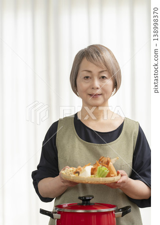 廚房裡，一位老婦人正在煮蔬菜湯。 138998370