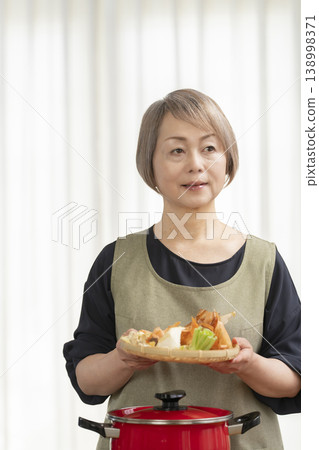 廚房裡，一位老婦人正在煮蔬菜湯。 138998371