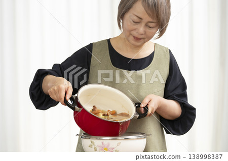 Senior woman making vegetable broth in the kitchen 138998387