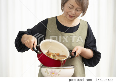 廚房裡，一位老婦人正在煮蔬菜湯。 138998388