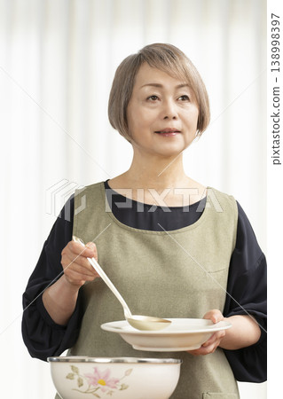 廚房裡，一位老婦人正在煮蔬菜湯。 138998397