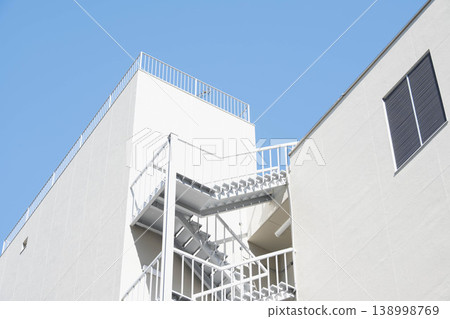 一棟設計極簡的白色建築,配有消防逃生通道。 一棟設計極簡的白色建築,配有消防逃生通道。 138998769