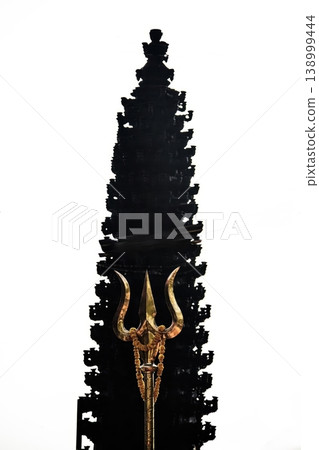 Golden Trishula Trident in Front of Hindu Temple Silhouette Against White Sky Golden Trishula Trident in Front of Hindu Temple Silhouette Against White Sky 138999444