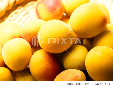 An image of many green plums piled in a bush to make pickled plums. 138999545