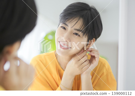一位戴著耳環、微笑的女性;平靜的日常生活;自然的生活方式。 一位戴著耳環、微笑的女性;平靜的日常生活;自然的生活方式。 139000112