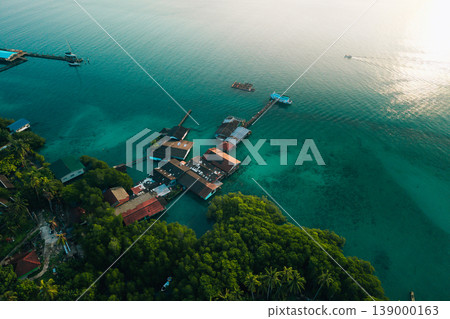 Aerial view of a traditional coastal village living in harmony with nature, showcasing sustainable living and slow life. Aerial view of a traditional coastal village living in harmony with nature, showcasing sustainable living and slow life. 139000163