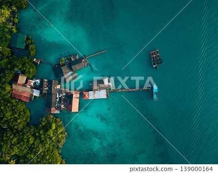 Aerial view of a traditional coastal village living in harmony with nature, showcasing sustainable living and slow life. Aerial view of a traditional coastal village living in harmony with nature, showcasing sustainable living and slow life. 139000164