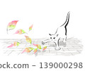 A cat playing with fallen leaves swirling in the wind on the cobblestone street. 139000298