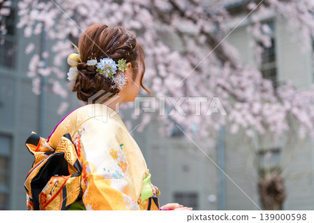 身穿和服的20歲女子，背景是盛開的櫻花。 139000598