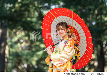 Women wearing kimonos or furisode (long-sleeved kimonos) and carrying traditional Japanese umbrellas at coming-of-age ceremonies. Women wearing kimonos or furisode (long-sleeved kimonos) and carrying traditional Japanese umbrellas at coming-of-age ceremonies. 139000602