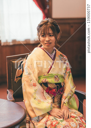 A 20-year-old woman in a furisode kimono is having her pre-coming-of-age ceremony photos taken in a retro studio. A 20-year-old woman in a furisode kimono is having her pre-coming-of-age ceremony photos taken in a retro studio. 139000737