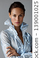 Fashion portrait woman studio futuristic jacket glowing reflective modern elegant neutral background, confident model wearing reflective futuristic jacket with glowing lines studio portrait 139001025
