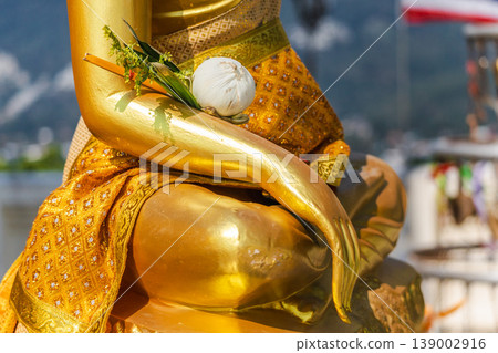 Close up of golden Buddha statue with lotus offering in hand at temple viewpoint in Koh Samui Close up of golden Buddha statue with lotus offering in hand at temple viewpoint in Koh Samui 139002916