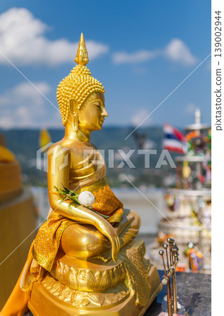 Golden Buddha statue with lotus offering and Thai flag on viewpoint in Koh Samui Thailand Golden Buddha statue with lotus offering and Thai flag on viewpoint in Koh Samui Thailand 139002944