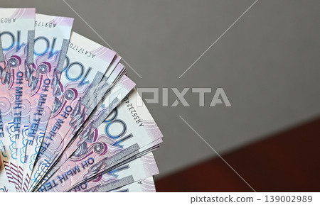 Holding a fan of colorful banknotes in hand during a financial transaction at a local market in the afternoon light Holding a fan of colorful banknotes in hand during a financial transaction at a local market in the afternoon light 139002989