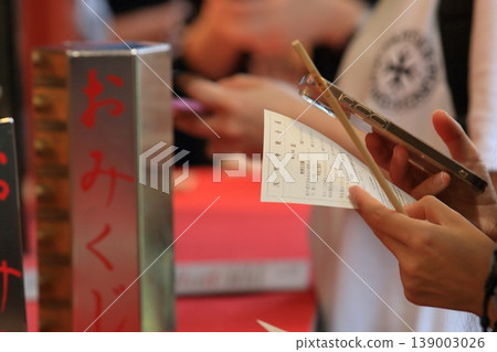 Tourists drawing fortune slips at Sensoji Temple Tourists drawing fortune slips at Sensoji Temple 139003026