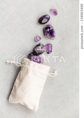 Amethyst Crystals in Cotton Pouch on Stone Background Amethyst Crystals in Cotton Pouch on Stone Background 139003489