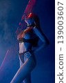Sensual woman in chainmail lingerie under red laser beam and blue light 139003607