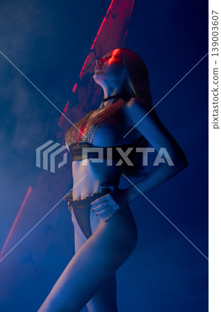 Sensual woman in chainmail lingerie under red laser beam and blue light Sensual woman in chainmail lingerie under red laser beam and blue light 139003607