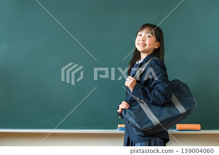 Female students in uniforms holding school bags standing in front of the blackboard in the classroom, elementary school, junior high school, and high school students Female students in uniforms holding school bags standing in front of the blackboard in the classroom, elementary school, junior high school, and high school students 139004060