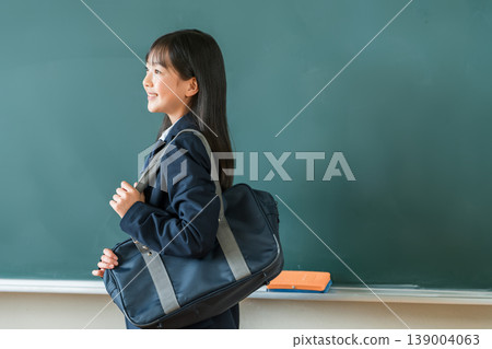 Female students in uniforms holding school bags standing in front of the blackboard in the classroom, elementary school, junior high school, and high school students Female students in uniforms holding school bags standing in front of the blackboard in the classroom, elementary school, junior high school, and high school students 139004063
