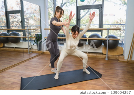 Stretching and balance exercise, personal training concept, healthy lifestyle and fitness coaching. Stretching and balance exercise, personal training concept, healthy lifestyle and fitness coaching. 139004297
