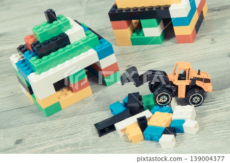 Small houses made of toy blocks and miniature excavator Small houses made of toy blocks and miniature excavator 139004377