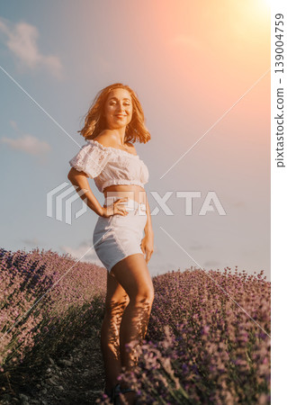 Lavender woman sunset woman in white clothes posing in a blooming purple field at golden hour with blue sky and copy space Lavender woman sunset woman in white clothes posing in a blooming purple field at golden hour with blue sky and copy space 139004759