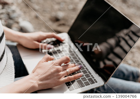 Laptop typing freelance professional working outdoors on a portable computer during a sunny day at a park with copy space Laptop typing freelance professional working outdoors on a portable computer during a sunny day at a park with copy space 139004766