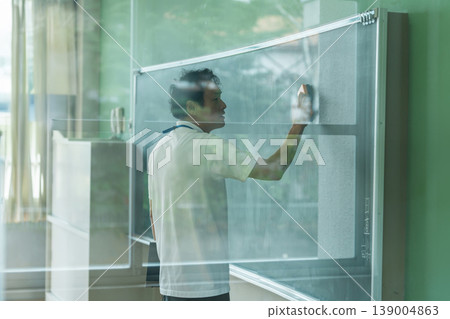 Male teacher giving a lesson in front of the blackboard 139004863