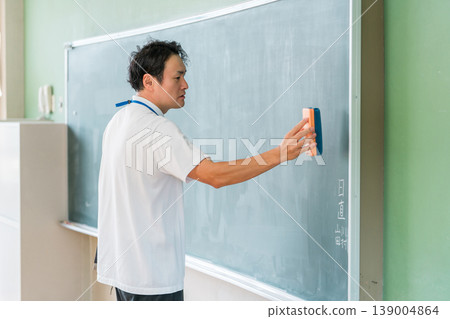 Male teacher giving a lesson in front of the blackboard 139004864