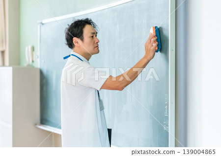 Male teacher giving a lesson in front of the blackboard 139004865