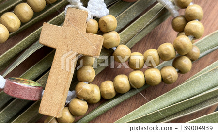 Holy Rosary with palm leaf background representing Christian faith prayer and reverence. Holy Rosary with palm leaf background representing Christian faith prayer and reverence. 139004939