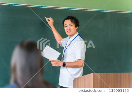 一位男老師在黑板前上課,學生們正在上課 一位男老師在黑板前上課,學生們正在上課 139005133