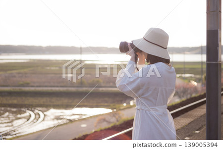 A woman waiting for a train on the platform of a rural station A woman waiting for a train on the platform of a rural station 139005394