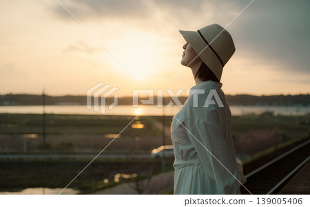 A woman waiting for a train on the platform of a rural station 139005406