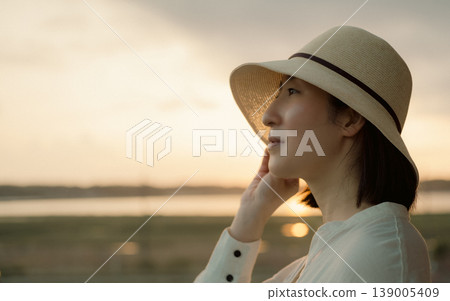 A woman waiting for a train on the platform of a rural station 139005409