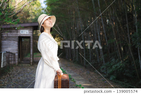 A woman waiting for a train on the platform of a rural station 139005574
