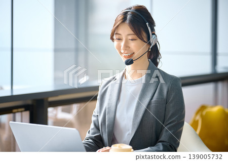A female call center operator who provides customer support and business support with a smile. A female call center operator who provides customer support and business support with a smile. 139005732