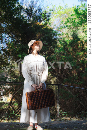 A woman waiting for a train on the platform of a rural station 139005777