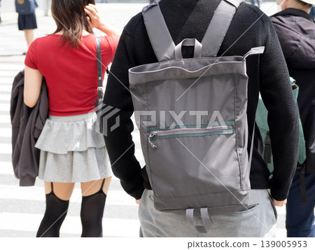 A person with a backpack on a street corner A person with a backpack on a street corner 139005953