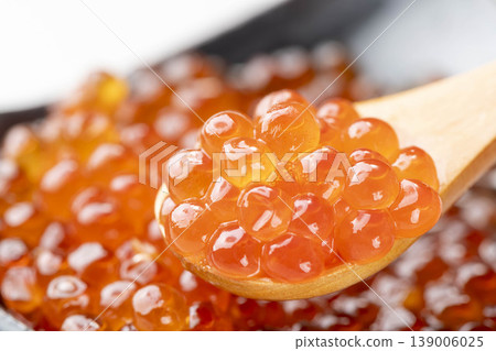 A close-up of salmon roe marinated in soy sauce, served on a spoon. The plump, glistening salmon eggs are beautiful, and it's high-quality salmon roe from Hokkaido. 139006025